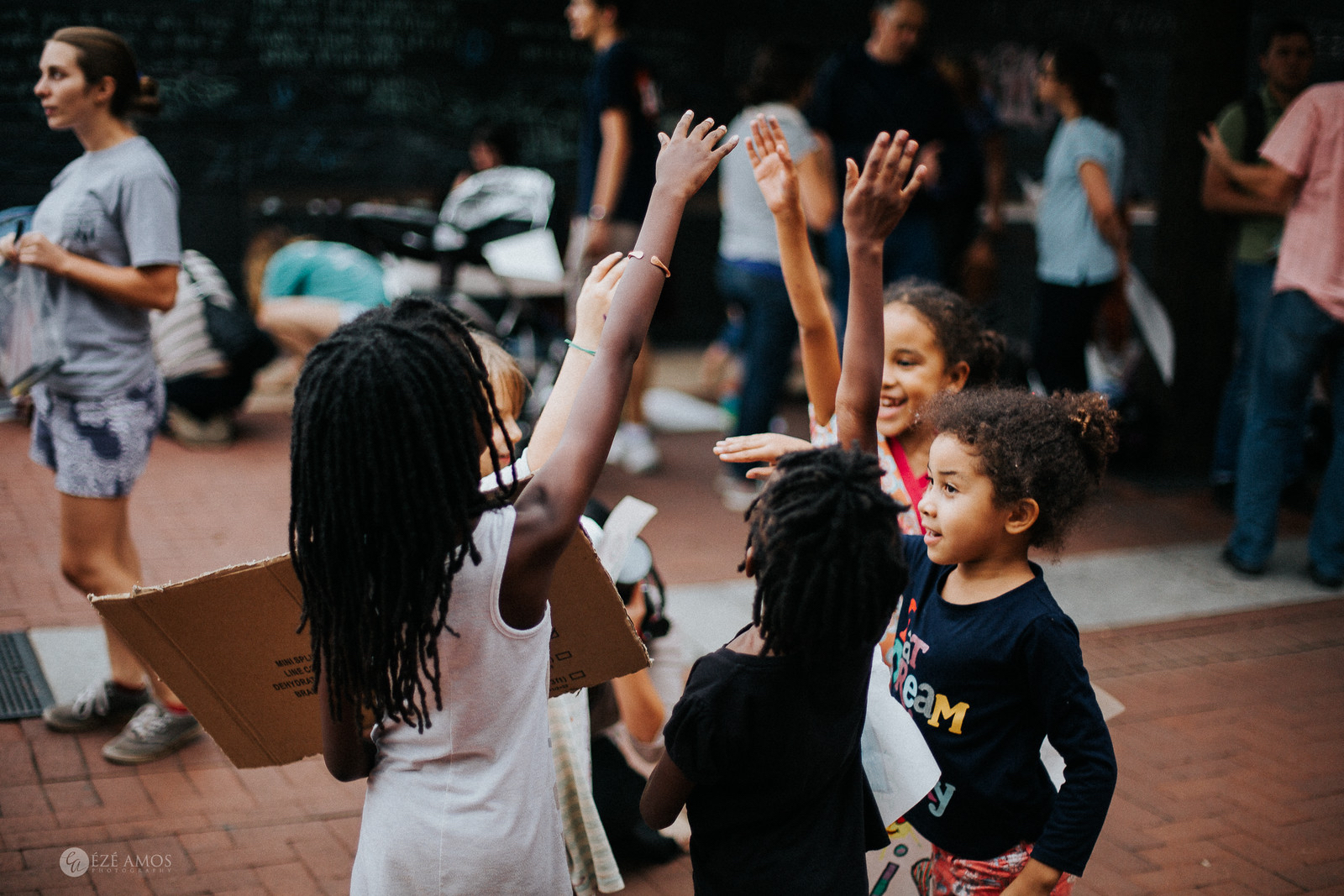 Photo of children in circle with hands raised.
