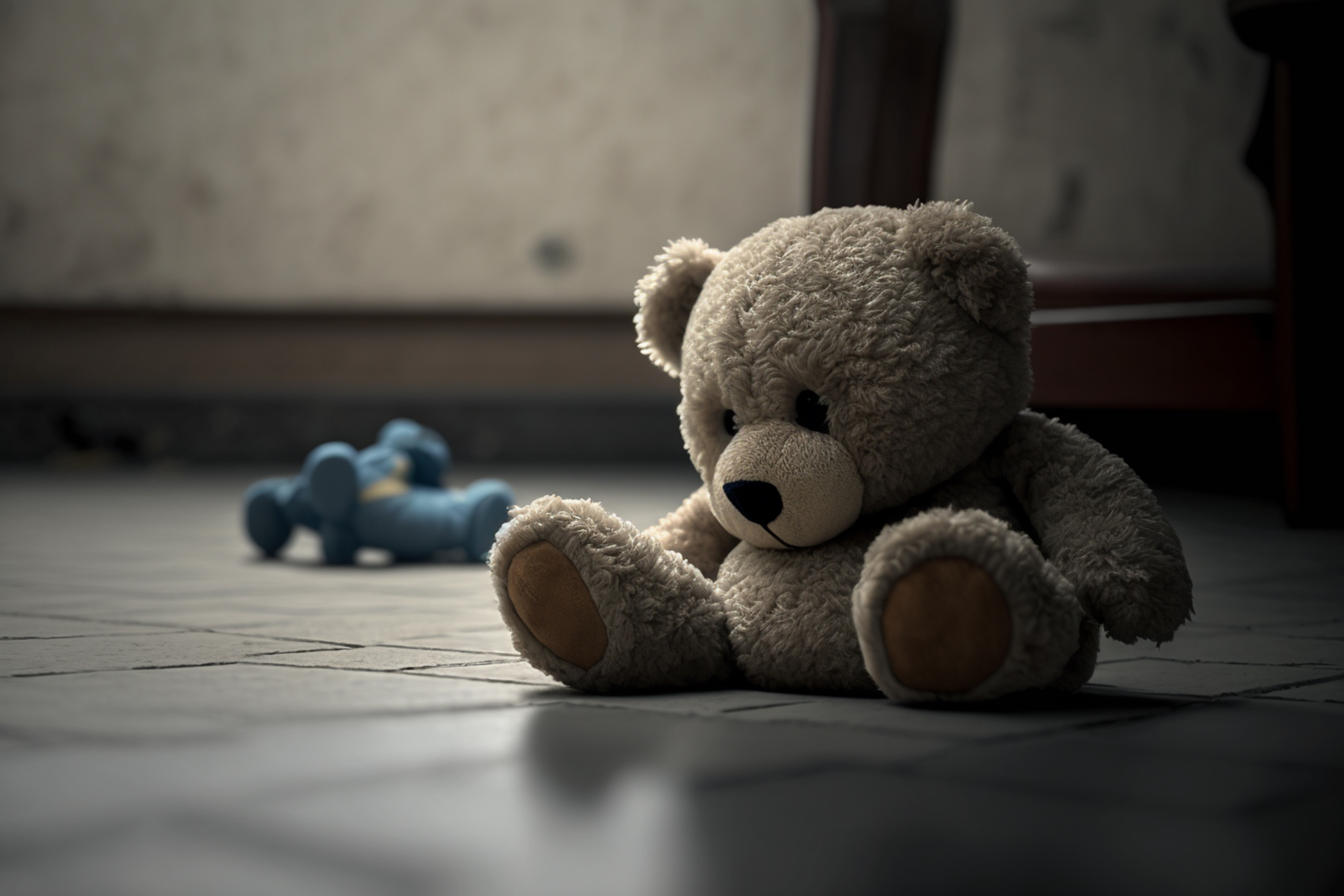 Photo of a stuffed teddy bear sitting on floor.